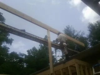 Carpenter setting a ridge beam over a new addition frame — Ice Dam Removal by Roofing Brothers in Ludlow Falls