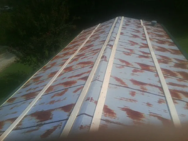 Rusted metal roof panels with new wood purlins before replacement — Storm Damage Roof Repair in Ludlow Falls by Roofing Brothers