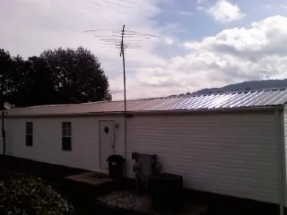 New metal roof on a single wide mobile home with a TV antenna in Ludlow Falls