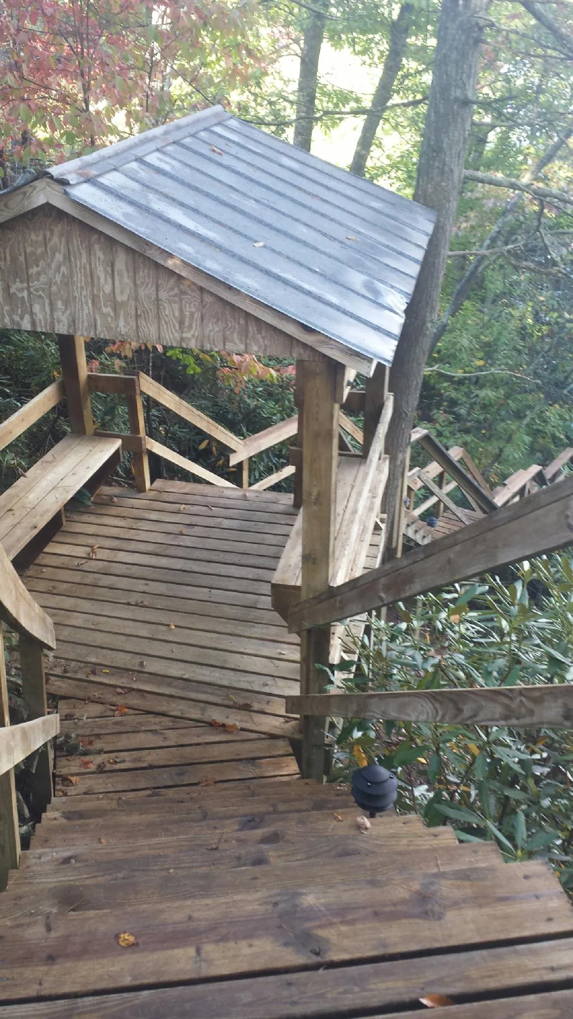 Metal roofed shelter over wooden steps on a wooded walkway — Skylight Repair & Installation work by our crew in Ludlow Falls