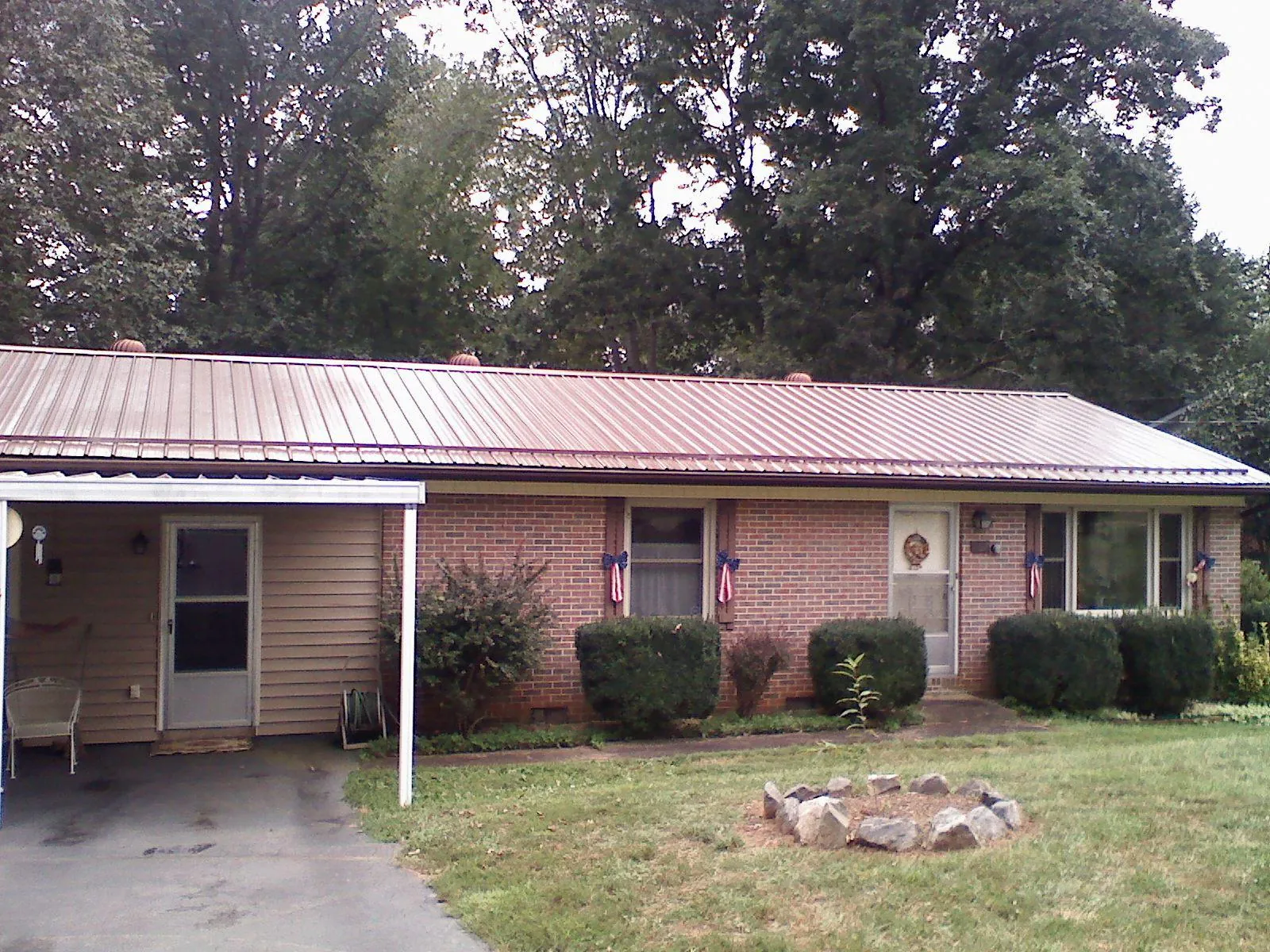 Bronze metal roof and carport on a brick ranch home — Roof Repair work by our crew in Ludlow Falls